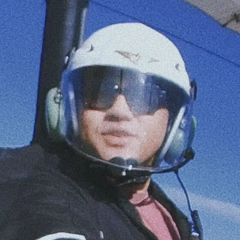 Houfu flying an ultralight trike, in a helmet and sunglasses