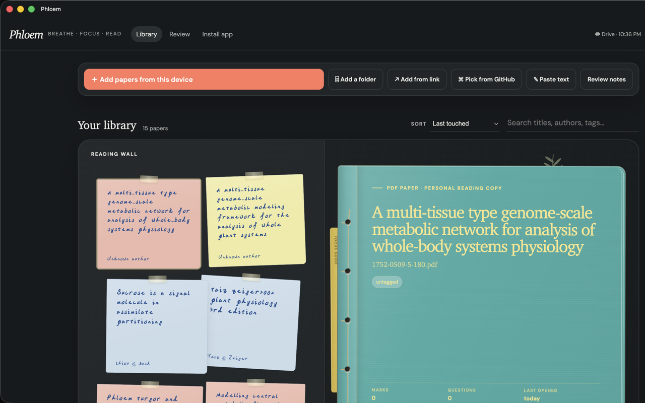 Phloem’s dark library with a reading wall and an open paper